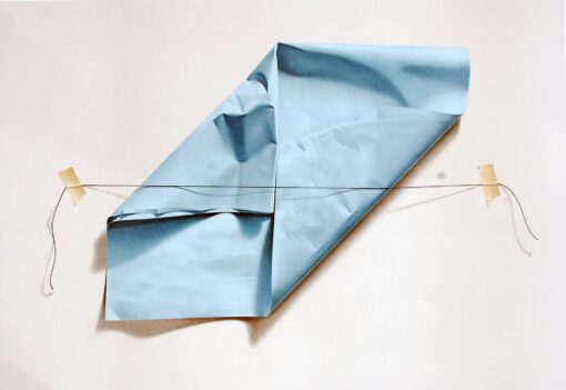 Crumpled blue silk paper pinned with a stretched thread across a pale background, creating a surreal illusion of Crumpled blue silk paper pinned with a stretched thread across a pale background, creating a surreal illusion of depth and fragility. Artwork by Yrjo Edelman.